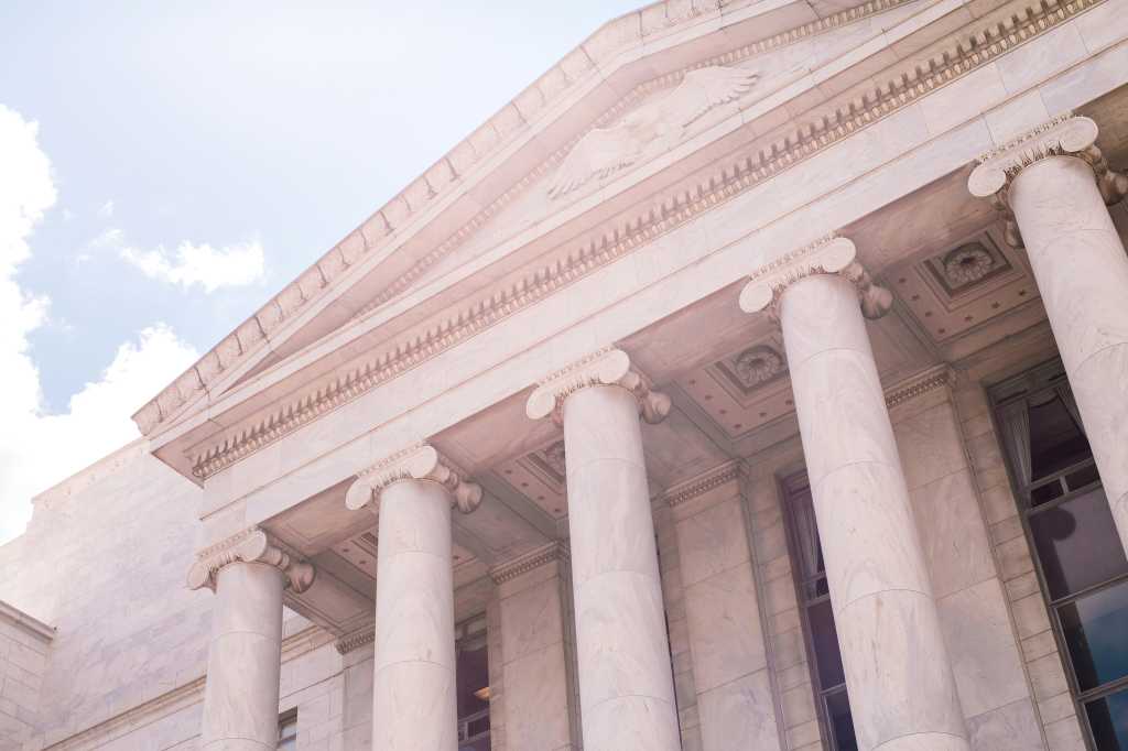 While marble and conrete government building with doric columns.